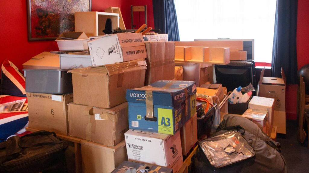 Volgestapelde kamer met dozen en spullen als voorbereiding op woningontruiming