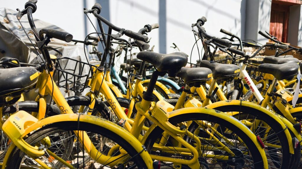 Gele huurfietsen staan dicht op elkaar geparkeerd in een opslagruimte of fietsenstalling