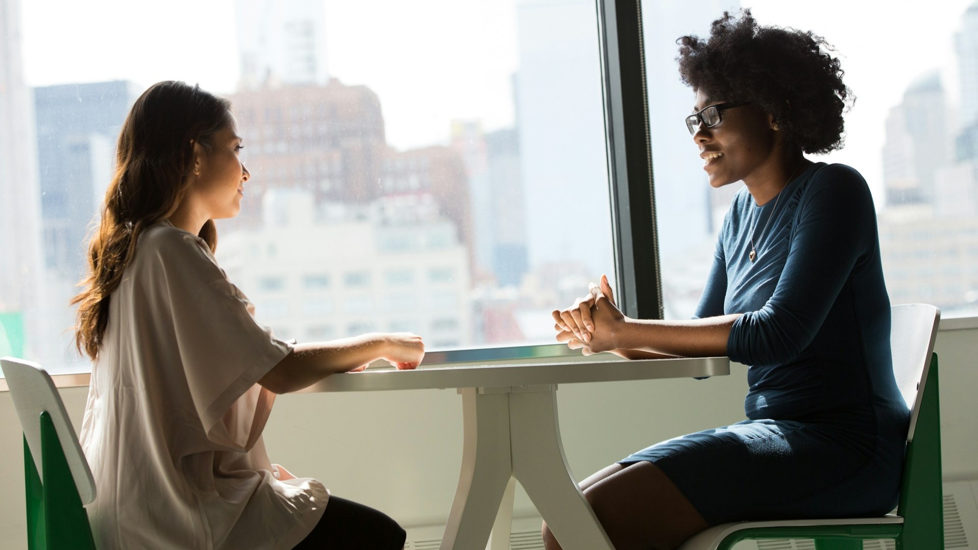 Twee vrouwen in gesprek aan tafel over zorgen rond een knobbeltje in borst en huisartsbezoek