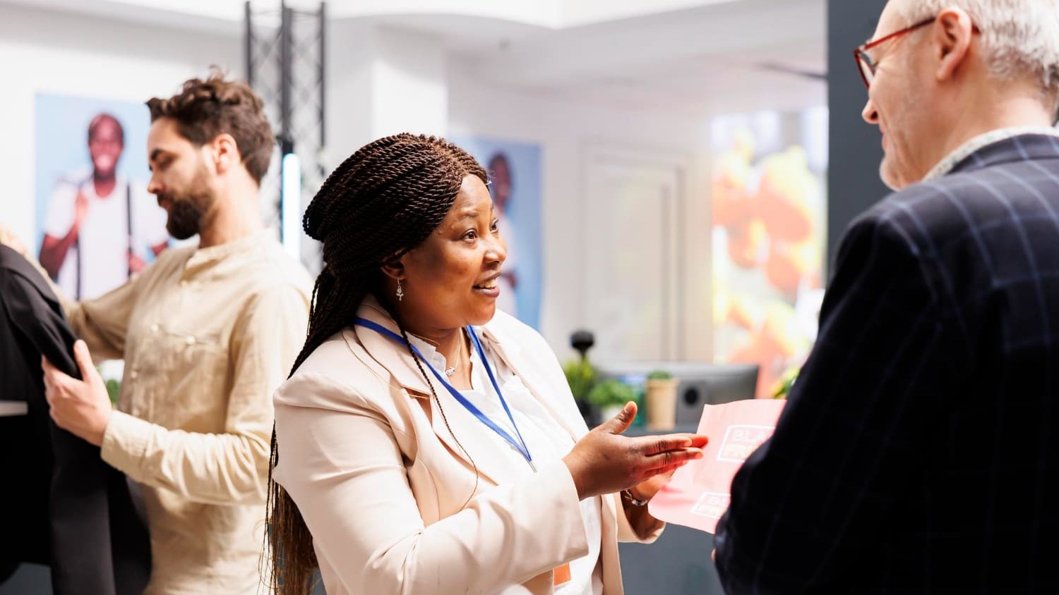 Vrouw in gesprek met een bezoeker op een vakbeurs, onderdeel van een goed voorbereide beursdeelname.