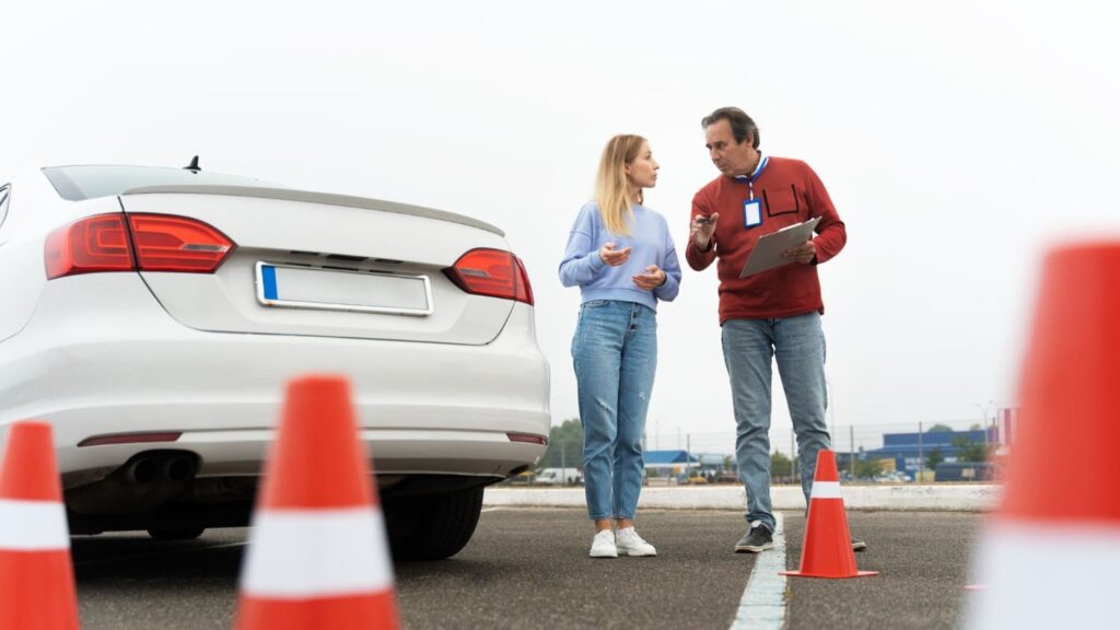 Rijinstructeur geeft uitleg aan cursist bij oefenparcours met focus op extra tijd theorie-examen.
