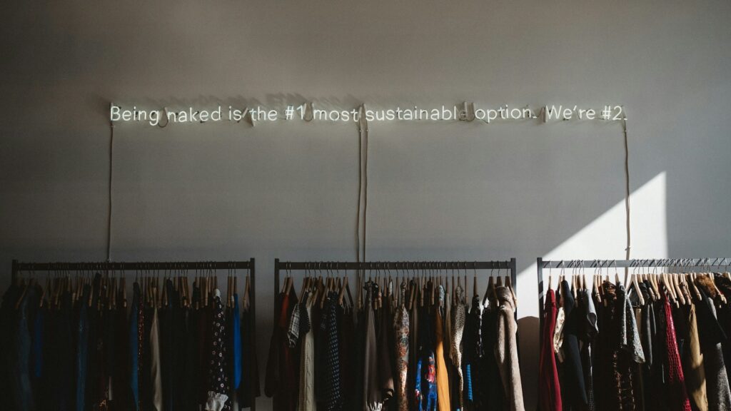 Kledingrekken met tweedehands kleding in winkel na kleding wegbrengen en sorteren