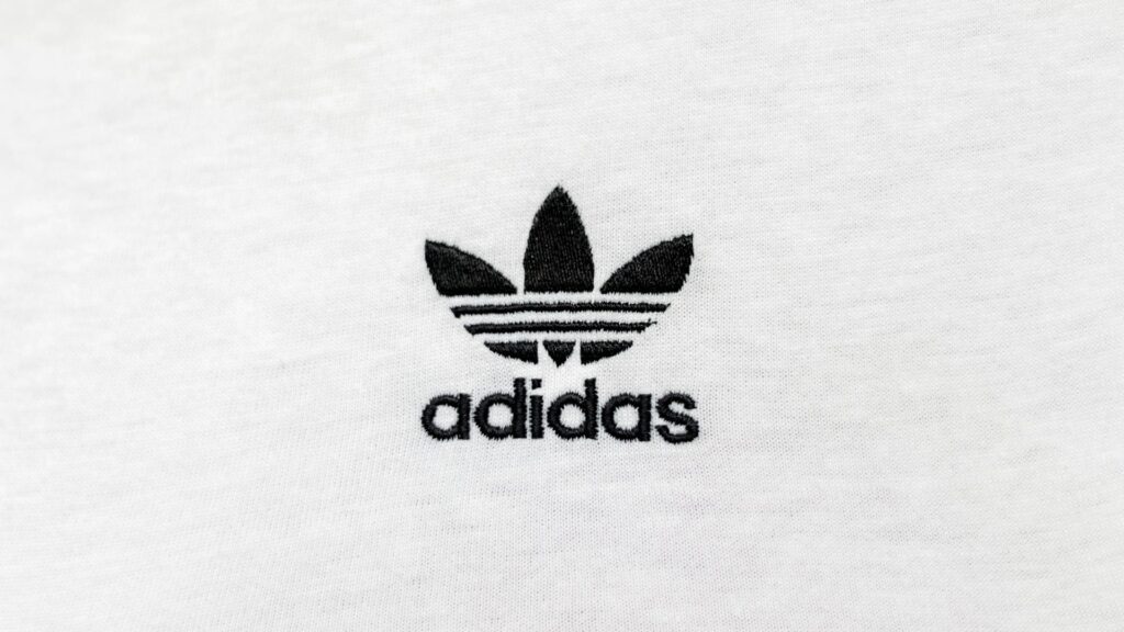 Close-up van Adidas logo op witte stof met duidelijke borduring en nette afwerking