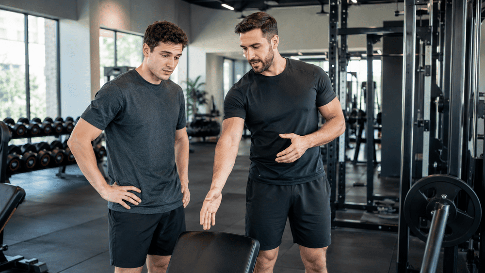 personal trainer geeft jongen advies over de oefening